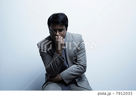 Studio portrait of businessman with hand over mouth 7912035