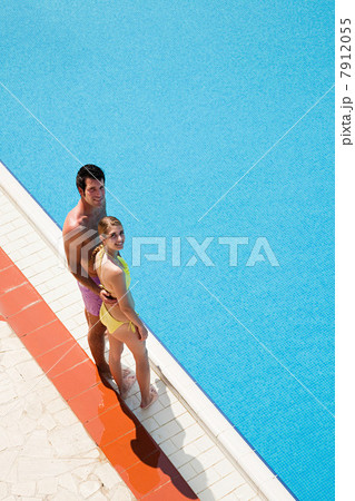 Young couple standing at poolside Young couple standing at poolside 7912055