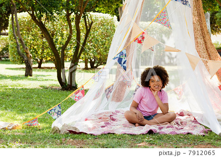 Girl sitting in summer netting tent 7912065