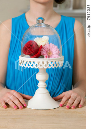 Woman and cake stand with flowers 7912083