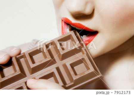 Young woman biting chocolate, close up 7912173