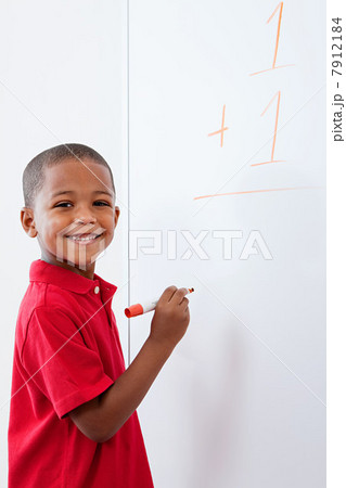 Boy with sum on whiteboard Boy with sum on whiteboard 7912184