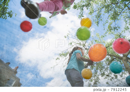 Young girls jumping on garden trampoline Young girls jumping on garden trampoline 7912245