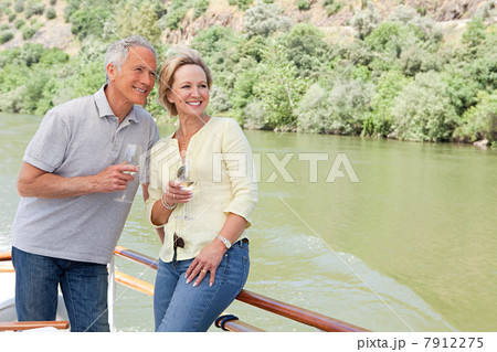 Senior couple with glasses of wine on a boat holiday 7912275