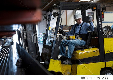 Worker using forklift in metal plant 7912331