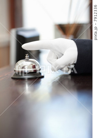 Bellhop ringing bell in hotel lobby 7912336