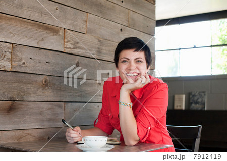 Woman wearing red shirt sitting in cafe, portrait Woman wearing red shirt sitting in cafe, portrait 7912419