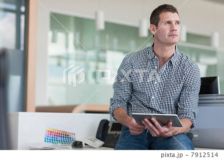 Man with digital tablet looking away 7912514