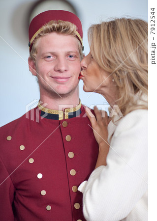 Older woman kissing bellhop?s cheek 7912544