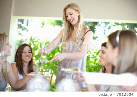 Woman serving salad at table 7912604