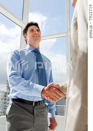Two businessmen shaking hands in office 7912714