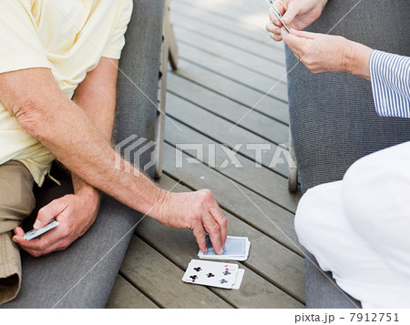 People playing cards outdoors 7912751
