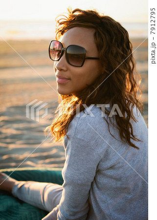 Smiling woman in sunglasses on beach 7912795