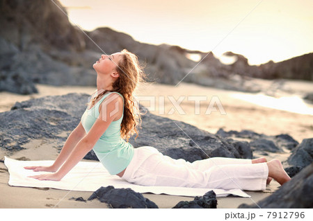 Young woman doing yoga on beach 7912796