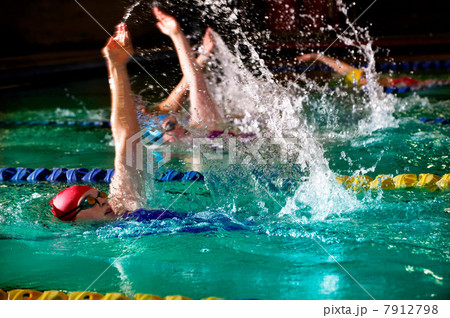 Female swimmers doing backstroke in swimming pool 7912798