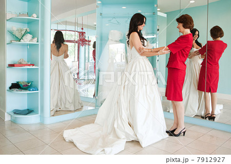 Daughter trying on wedding dress, holding hands 7912927