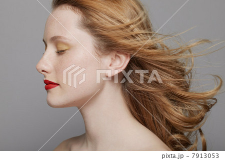 Profile of young woman with curly red hair wearing make up 7913053