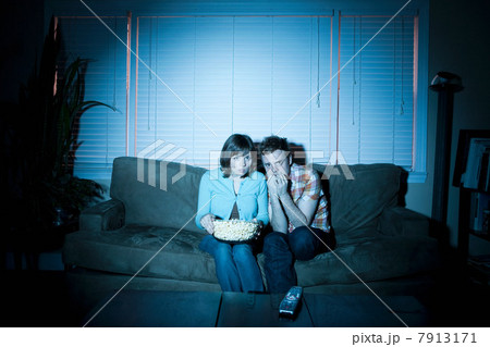 Young couple watching tv, man biting fingernails 7913171