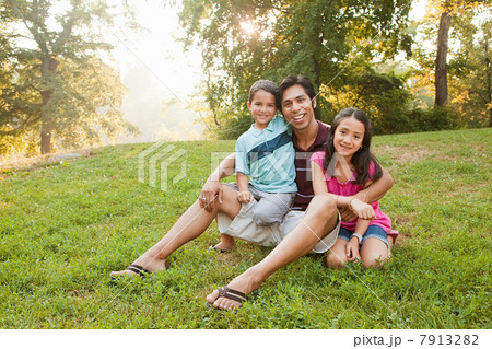 Father sitting with children in park, portrait 7913282