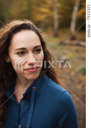 Young woman in forest smiling, looking away 7913321