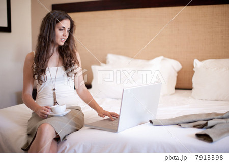 Young woman on bed using laptop 7913398