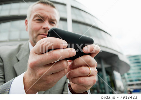 Businessman using smartphone outdoors Businessman using smartphone outdoors 7913423