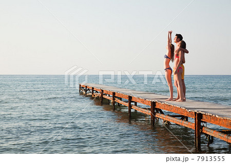 Young friends standing on jetty Young friends standing on jetty 7913555