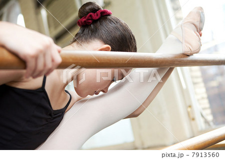 Ballerina stretching at barre 7913560