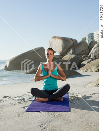Young woman doing yoga on beach 7913726