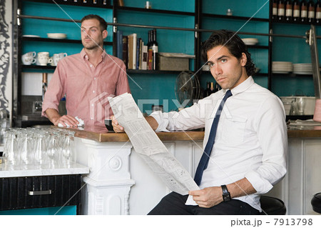 Man with newspaper and waiter in cafe Man with newspaper and waiter in cafe 7913798