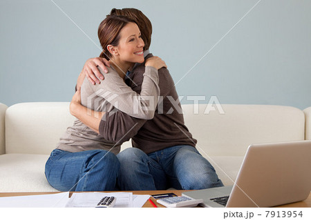 Young couple embracing, paperwork on table 7913954