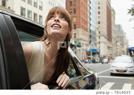 Young woman leaning out of taxicab window, looking up Young woman leaning out of taxicab window, looking up 7914035