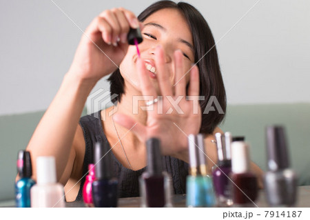 Young woman painting her fingernails Young woman painting her fingernails 7914187