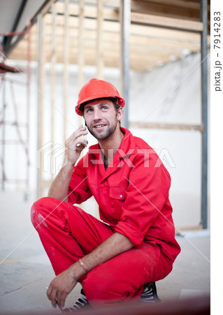 Builder on construction site on mobile phone 7914283