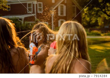 Girls having water fight with water pistols 7914284