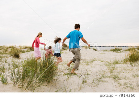 Young family running on beach 7914360