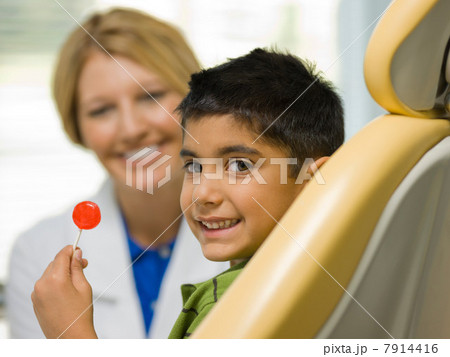 Young boy holding lollipop at the dentist's office, portrait 7914416