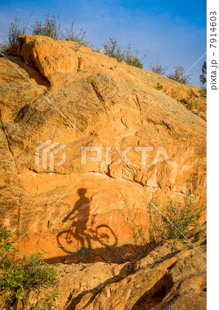 Shadow on rock of man and bike 7914603