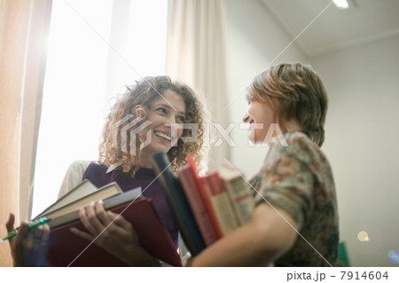 Students carrying books in library 7914604