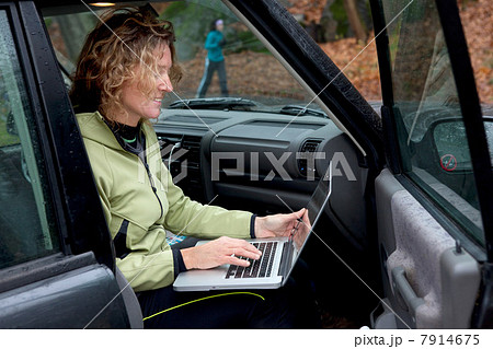 Mature woman using laptop in car Mature woman using laptop in car 7914675