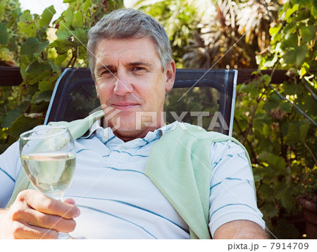 Man holding glass of white wine, portrait 7914709