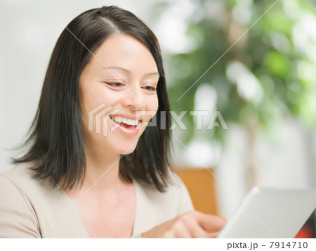 Mature woman using digital tablet and smiling 7914710