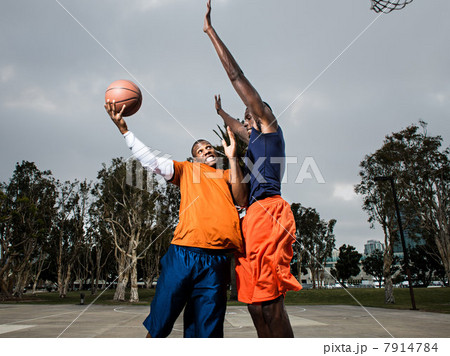 Young men playing basketball on court Young men playing basketball on court 7914784