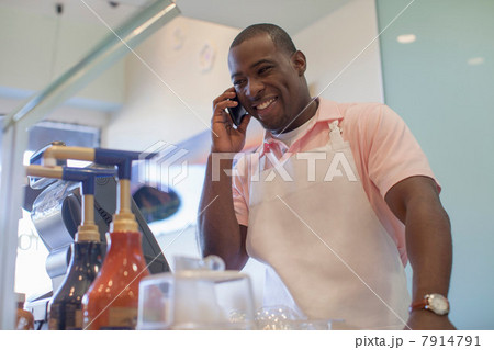 Cashier talking on cell phone in store 7914791