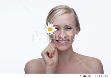 Young woman holding daisy 7914839