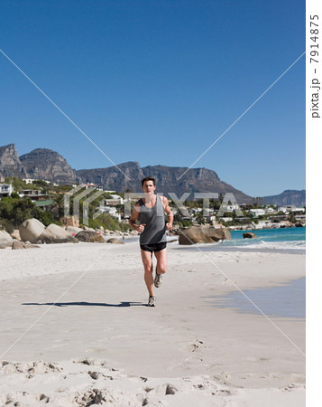Young man jogging on beach 7914875