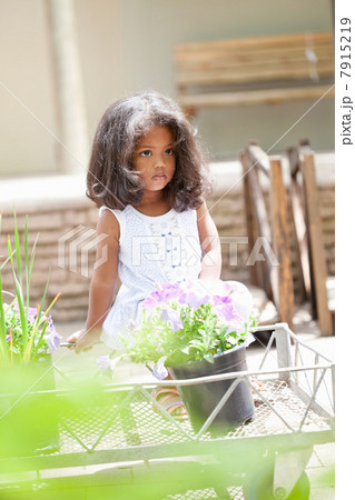 Girl sitting on cart in flower nursery 7915219