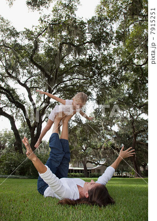 Girl balancing on feet of mother 7915251
