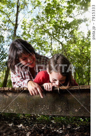 Mother and daughter lying on boardwalk 7915333