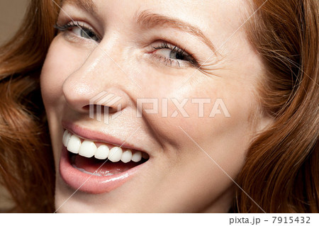 Woman looking at camera laughing, close up 7915432